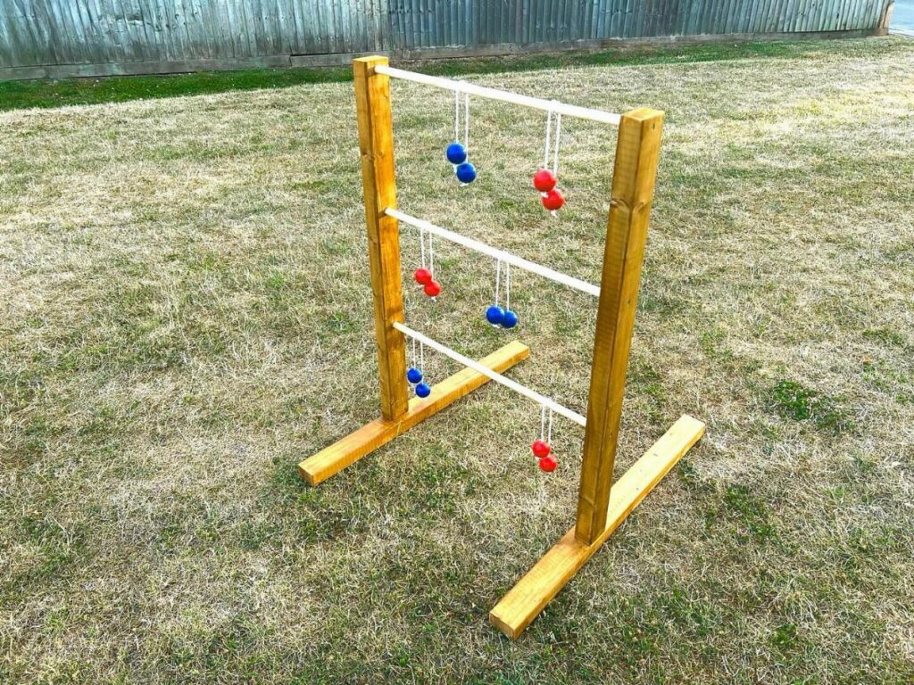 Wooden ladder golf game with red and blue balls on a grassy lawn