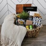 Woven gift basket with movie snacks, a blanket, and a movie ticket box.